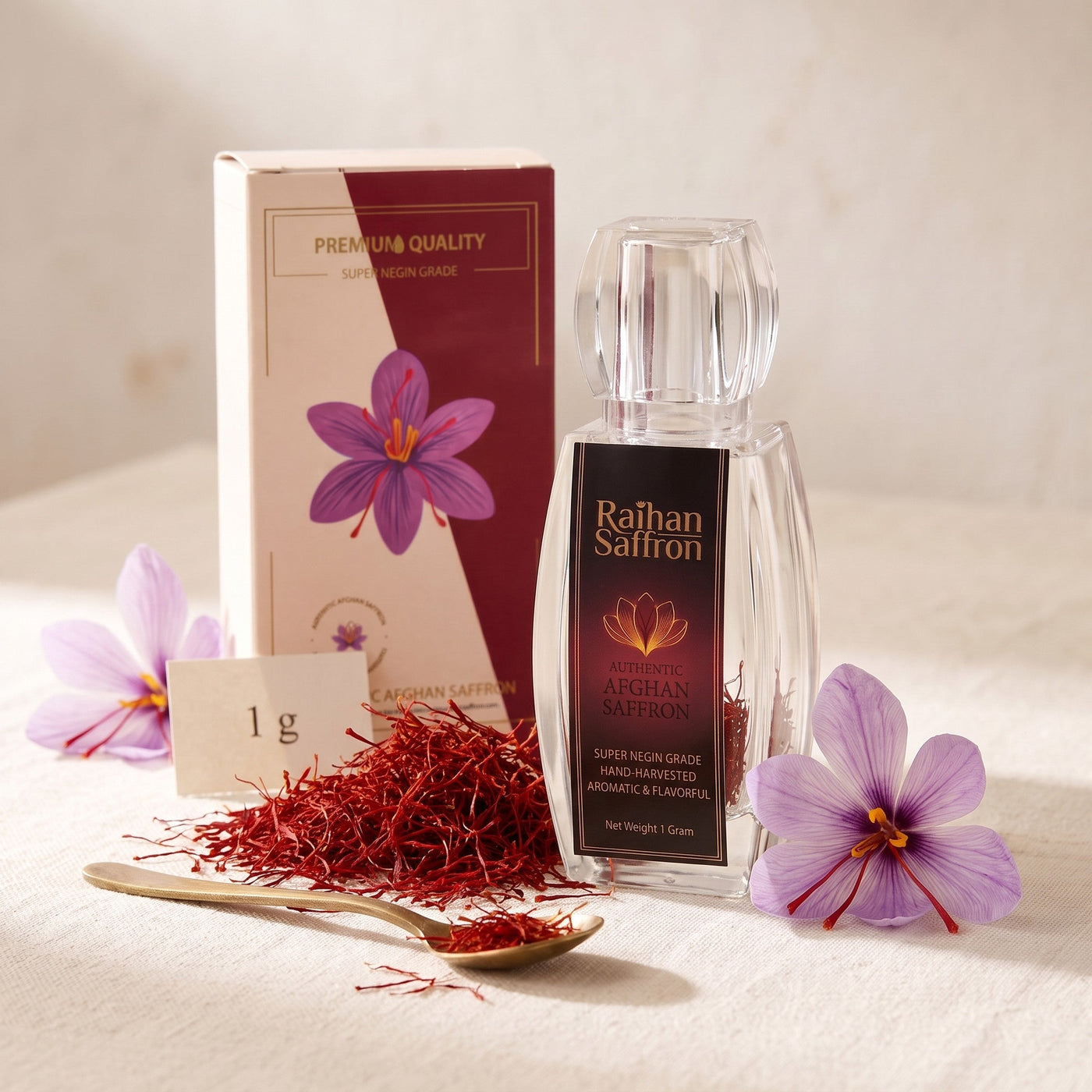 Raihan Saffron 1 g: Afghan Super Negin saffron crystal bottle and gift box with whole red saffron threads and crocus flowers on ivory linen