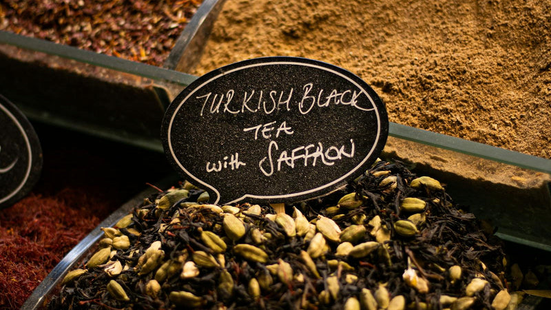Golden saffron tea in a clear glass with cardamom, brewed with Raihan Afghan Super Negin saffron