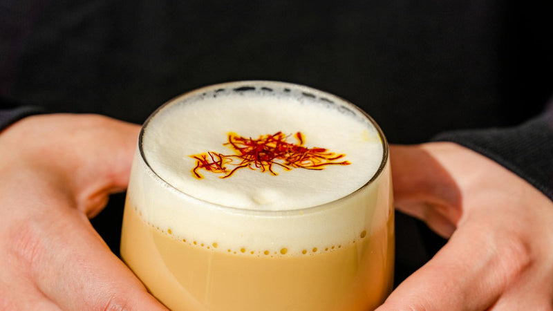 Afghan saffron chai steeping in a clear glass with cardamom, made with Raihan Afghan Super Negin saffron