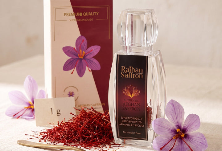 The 1 g bottle of Raihan Super Negin saffron with its gift box and crocus flowers on ivory linen