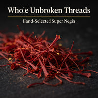 Whole unbroken Super Negin saffron threads macro on slate — hand-selected